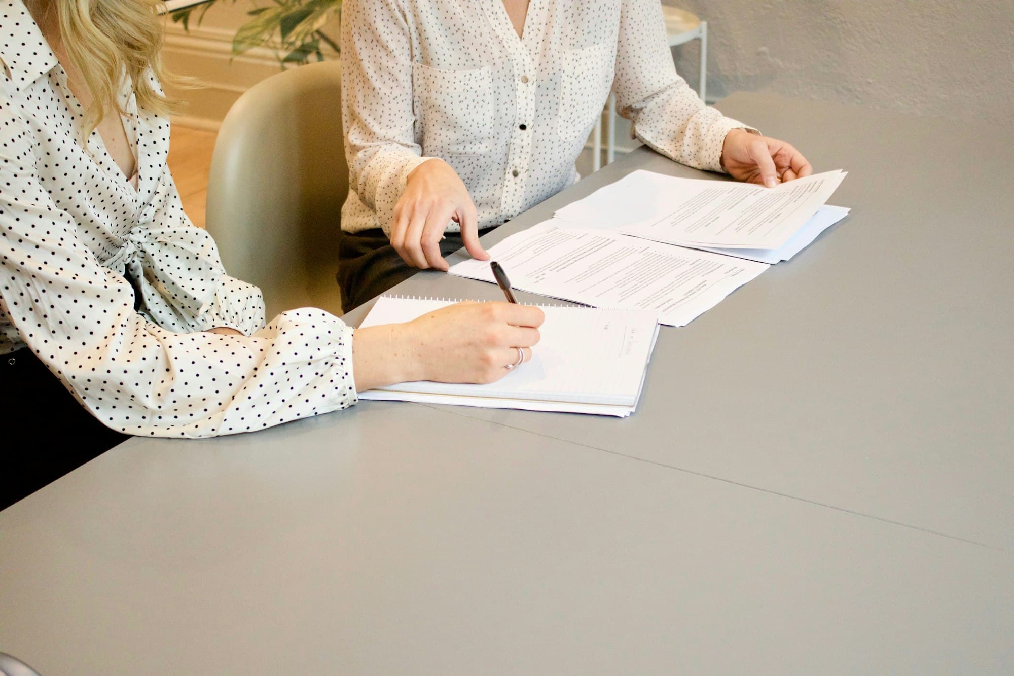Two people reviewing and signing paperwork at a table