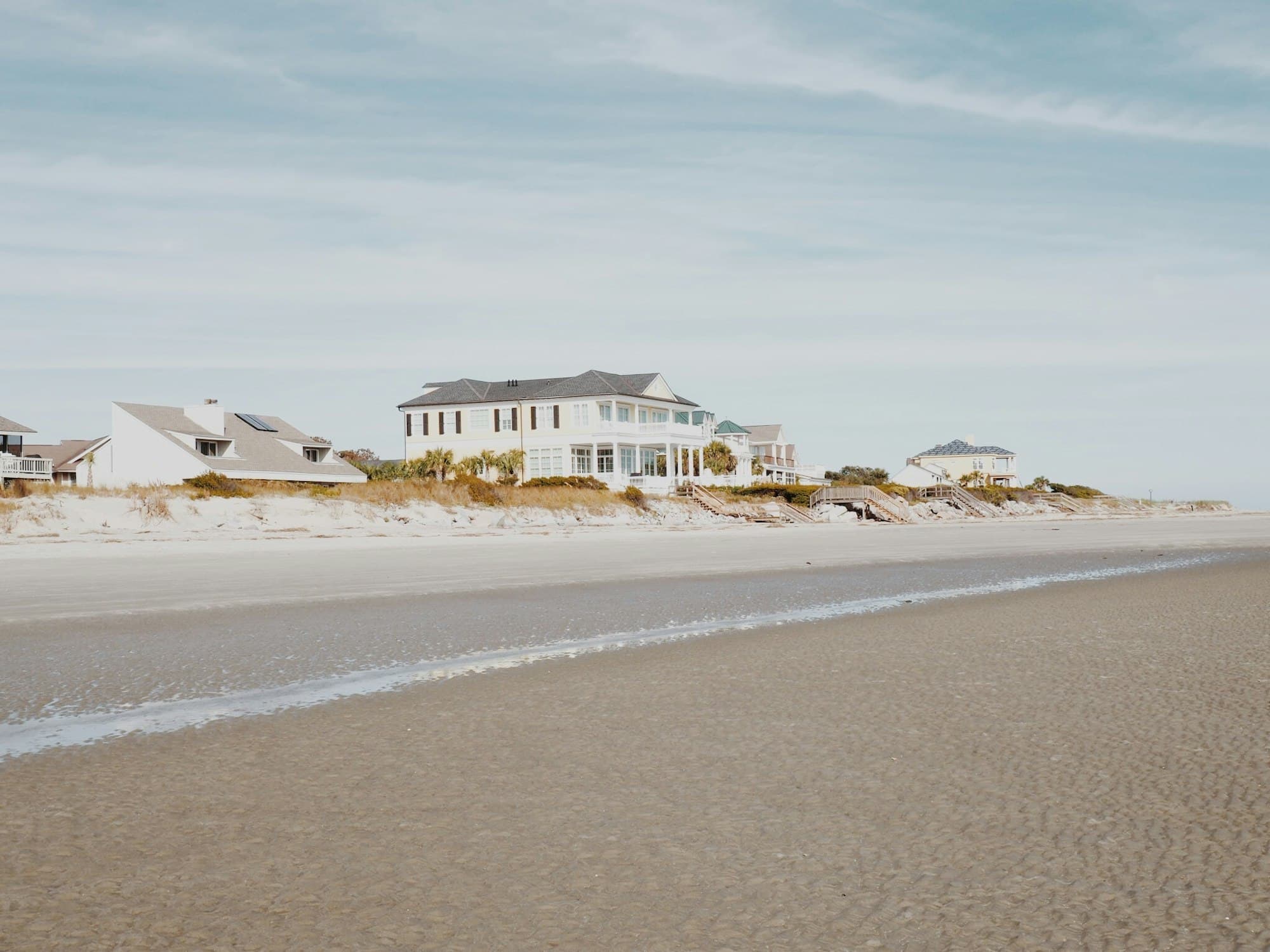 A white two-story coastal home overlooking the dunes