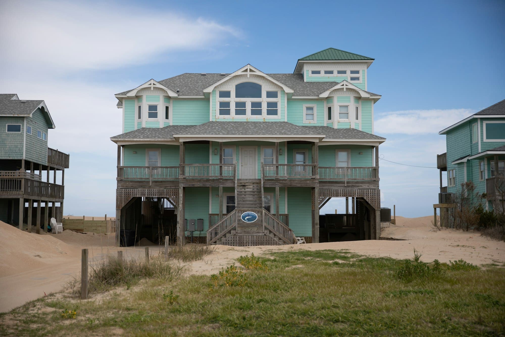 A large elevated beach house on pilings with covered porches on two levels
