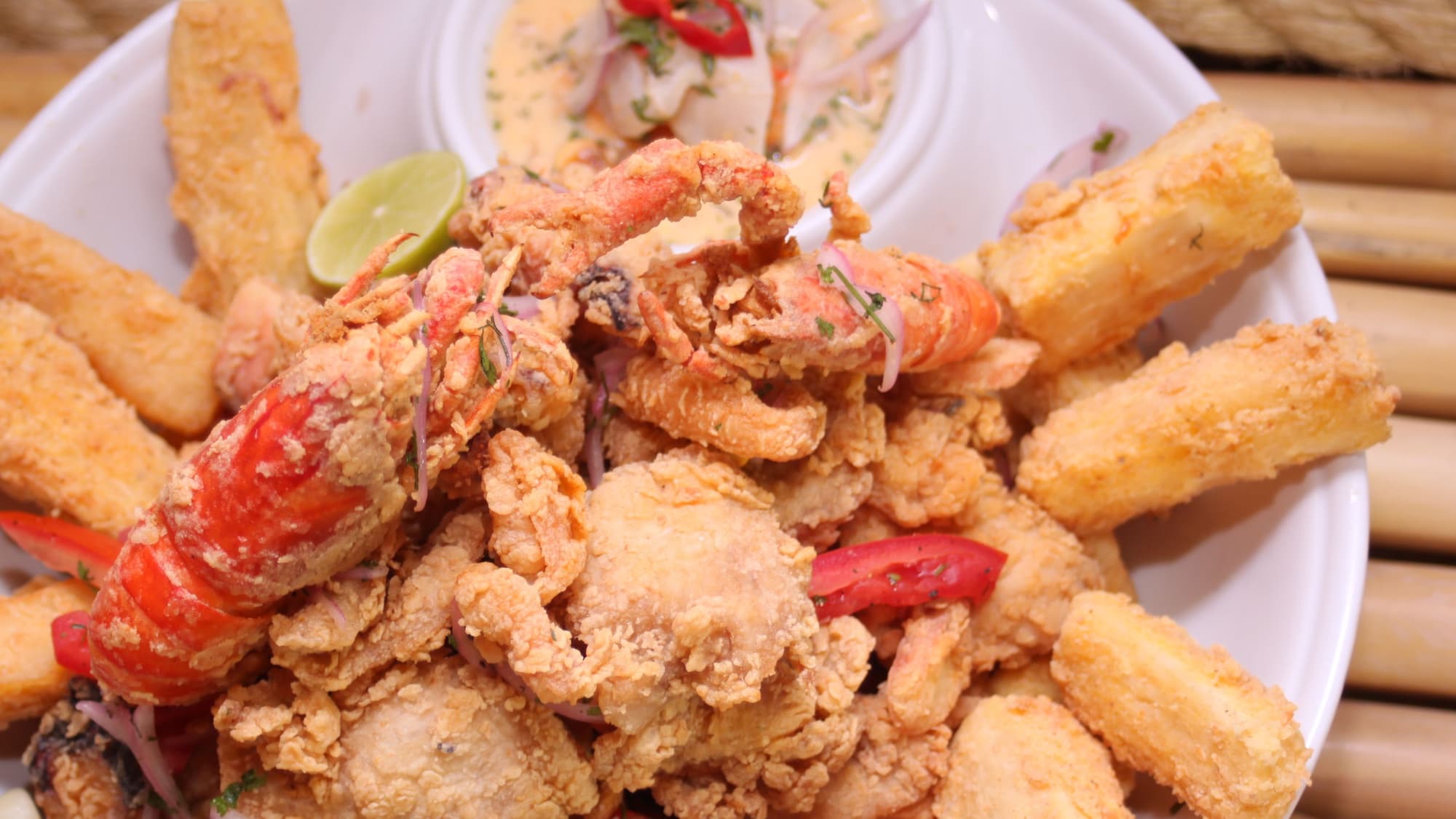 A generous mixed platter of golden fried seafood with lime wedges