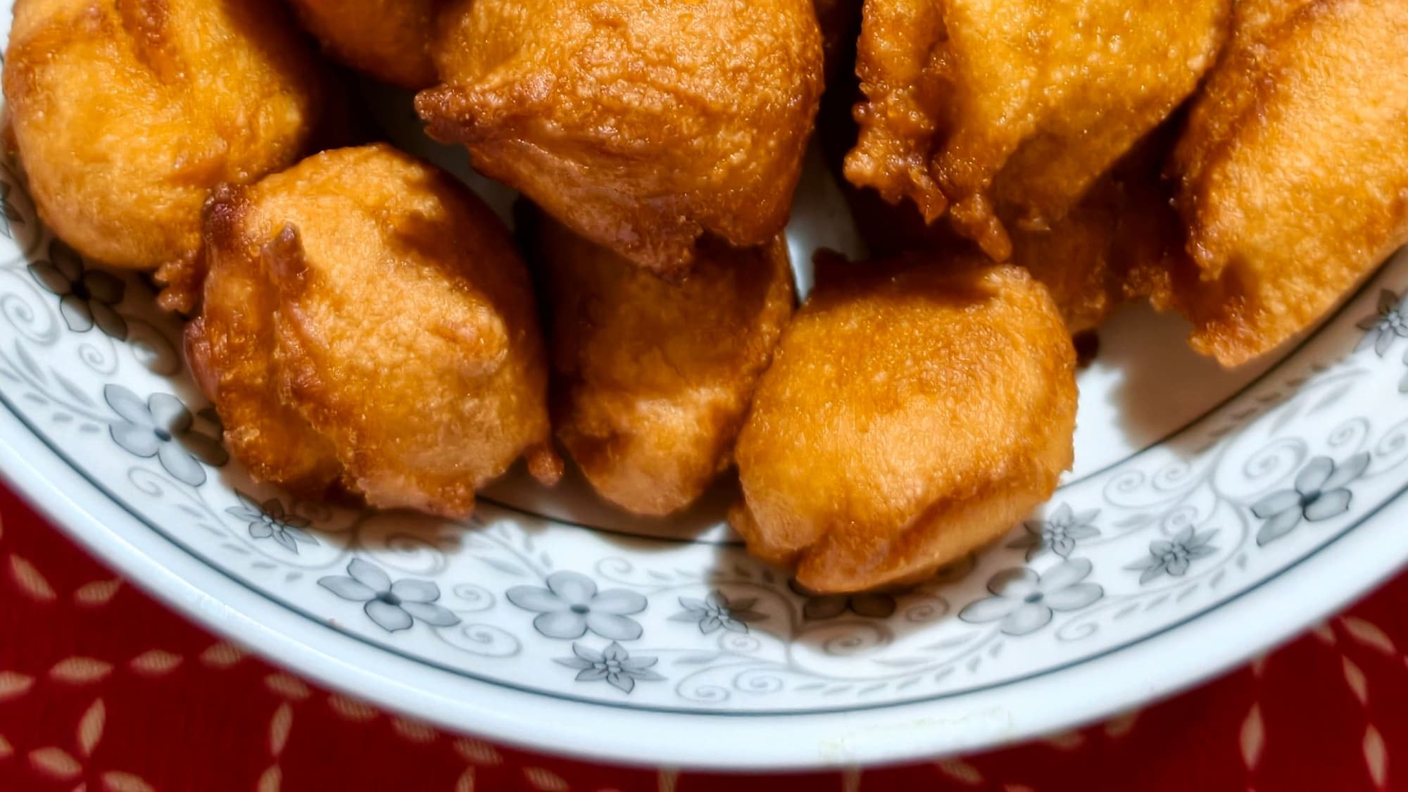 A bowl of golden fried bites on a decorative plate