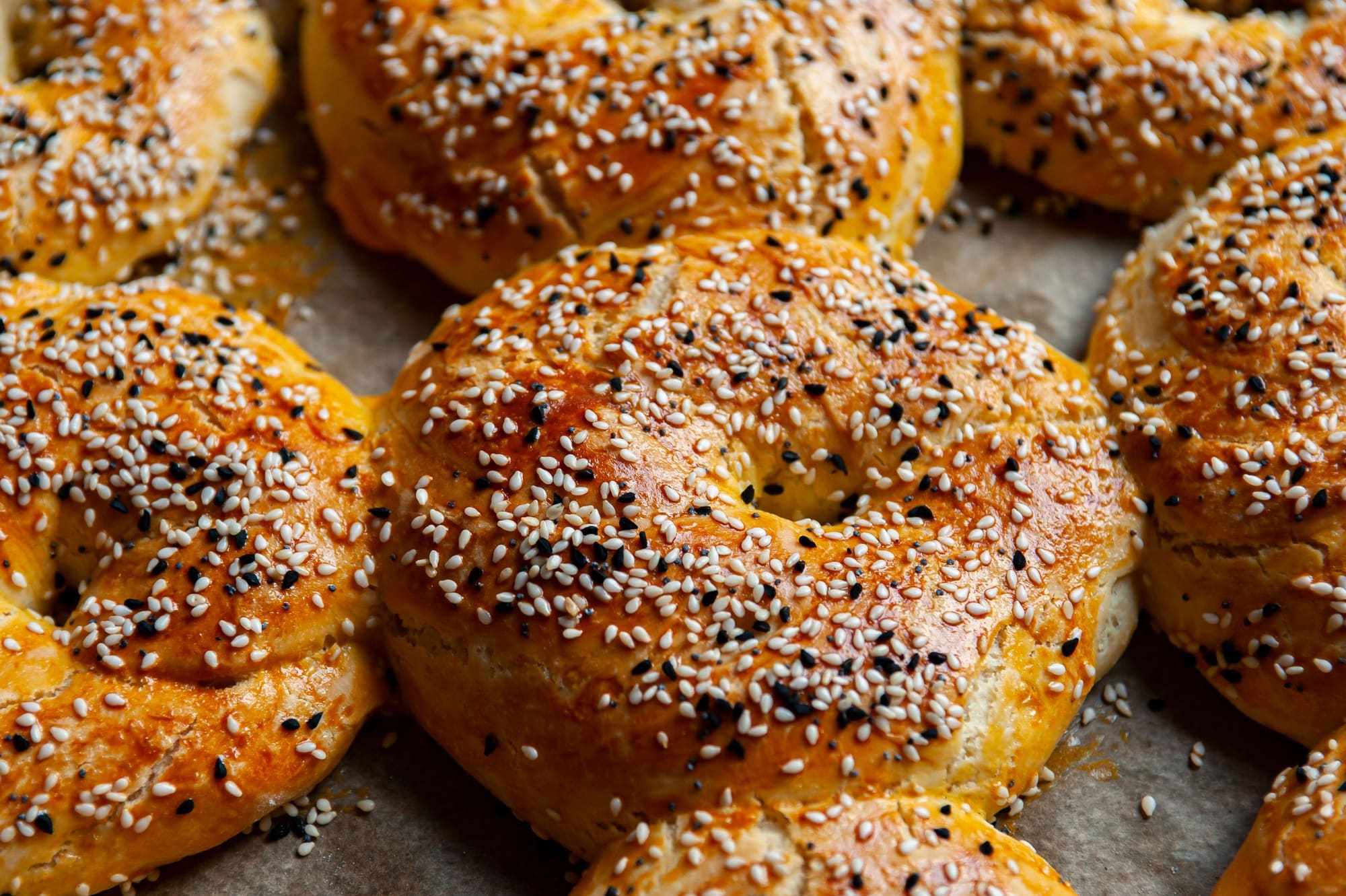 A tray of freshly baked bagels crusted with sesame seeds