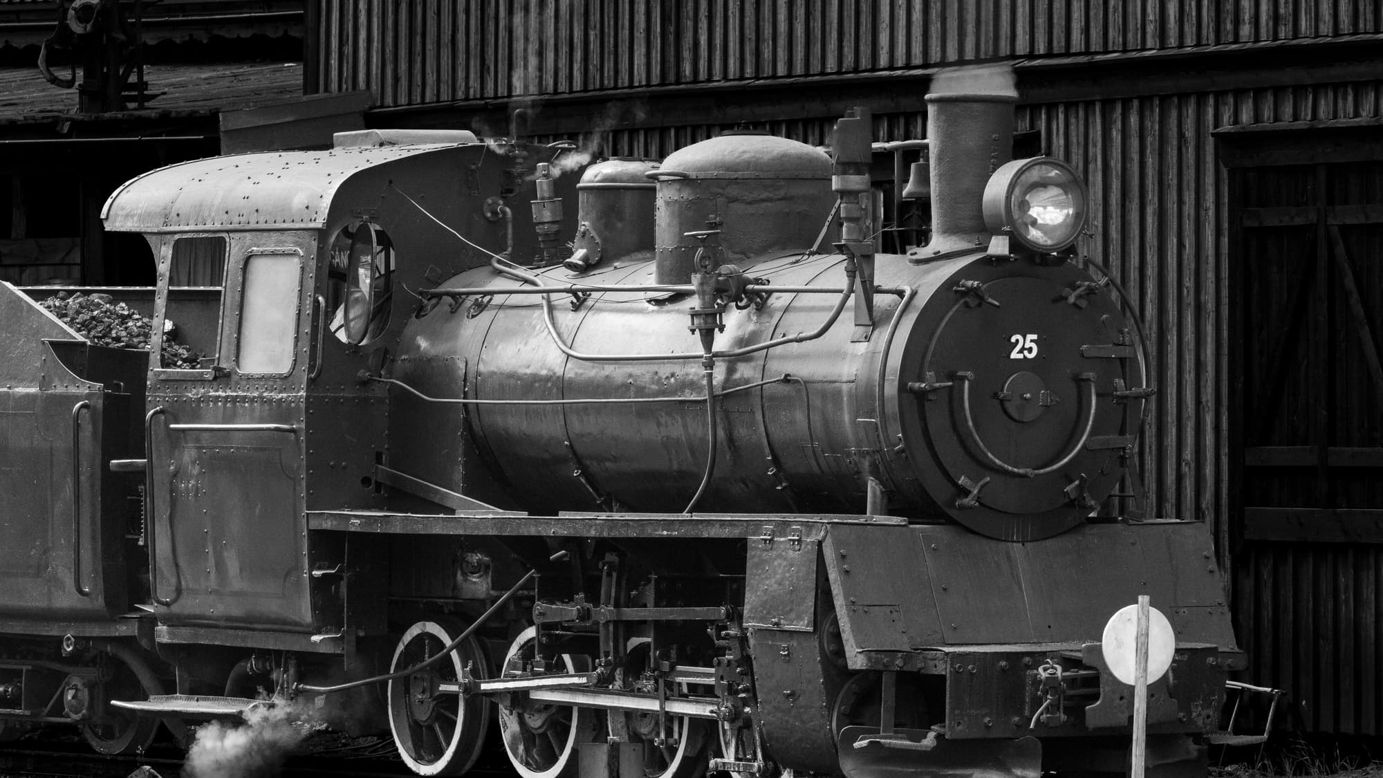 A vintage black steam locomotive parked at an old railway station